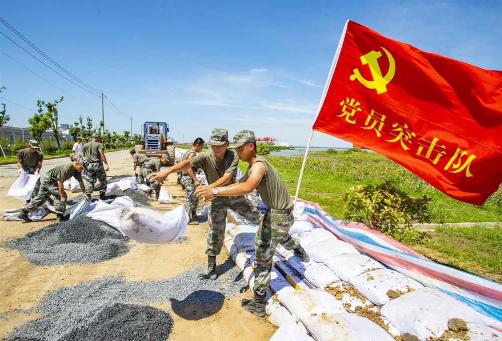 2020年8月2日,驰援江西省湖口抗洪抢险的官兵正在长江干堤,头顶烈日